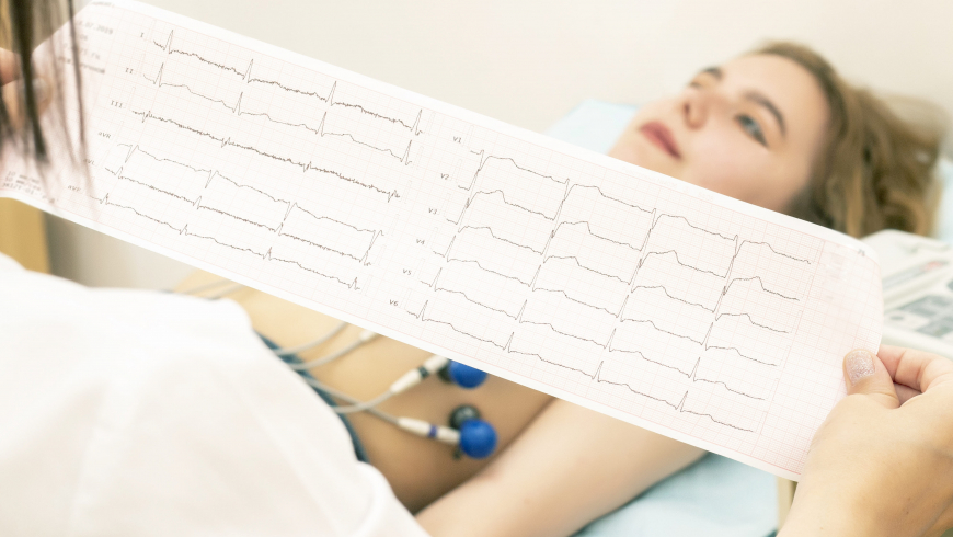 the doctor cardiologist looks at the printout of the cardiogram 7b8ab